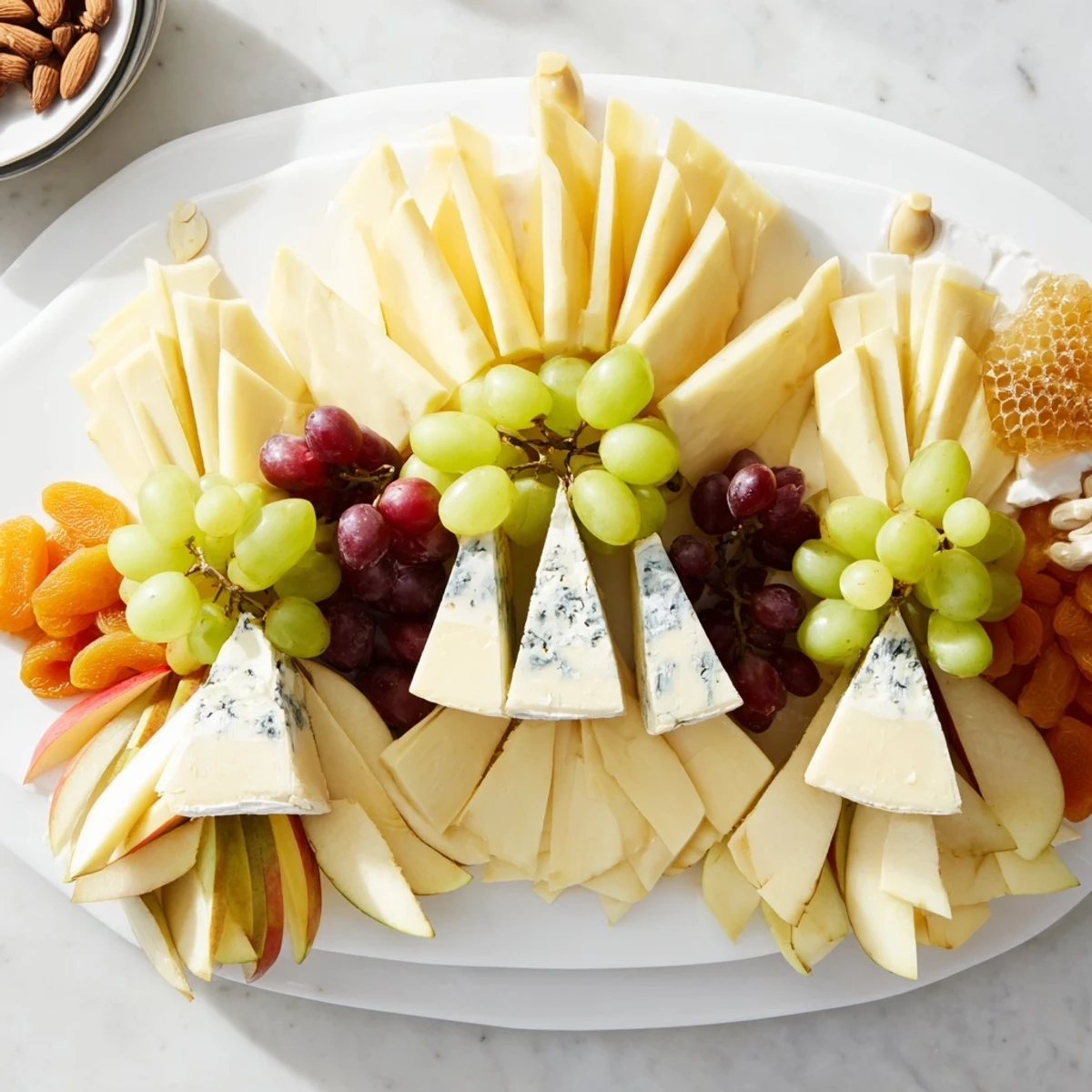 Art Deco Arch Cheese Platter with layered cheddar, grapes, and almonds; a beautiful appetizer.