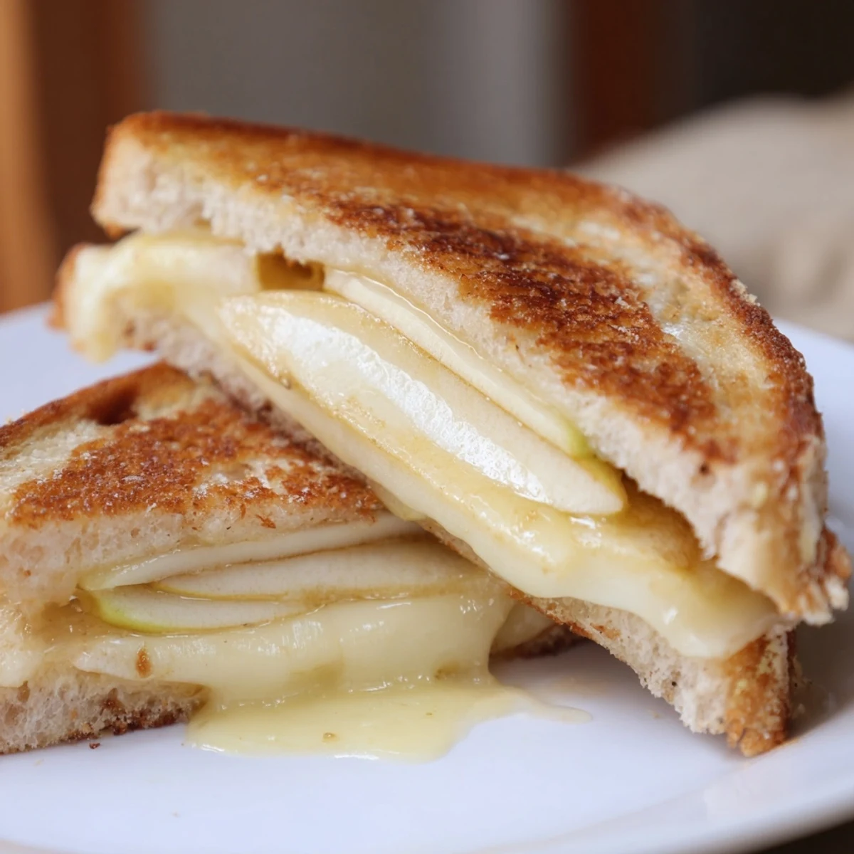 Mouthwatering Brie and Apple Grilled Cheese with melted Brie cheese, apples, and toasted sourdough, ready to eat.