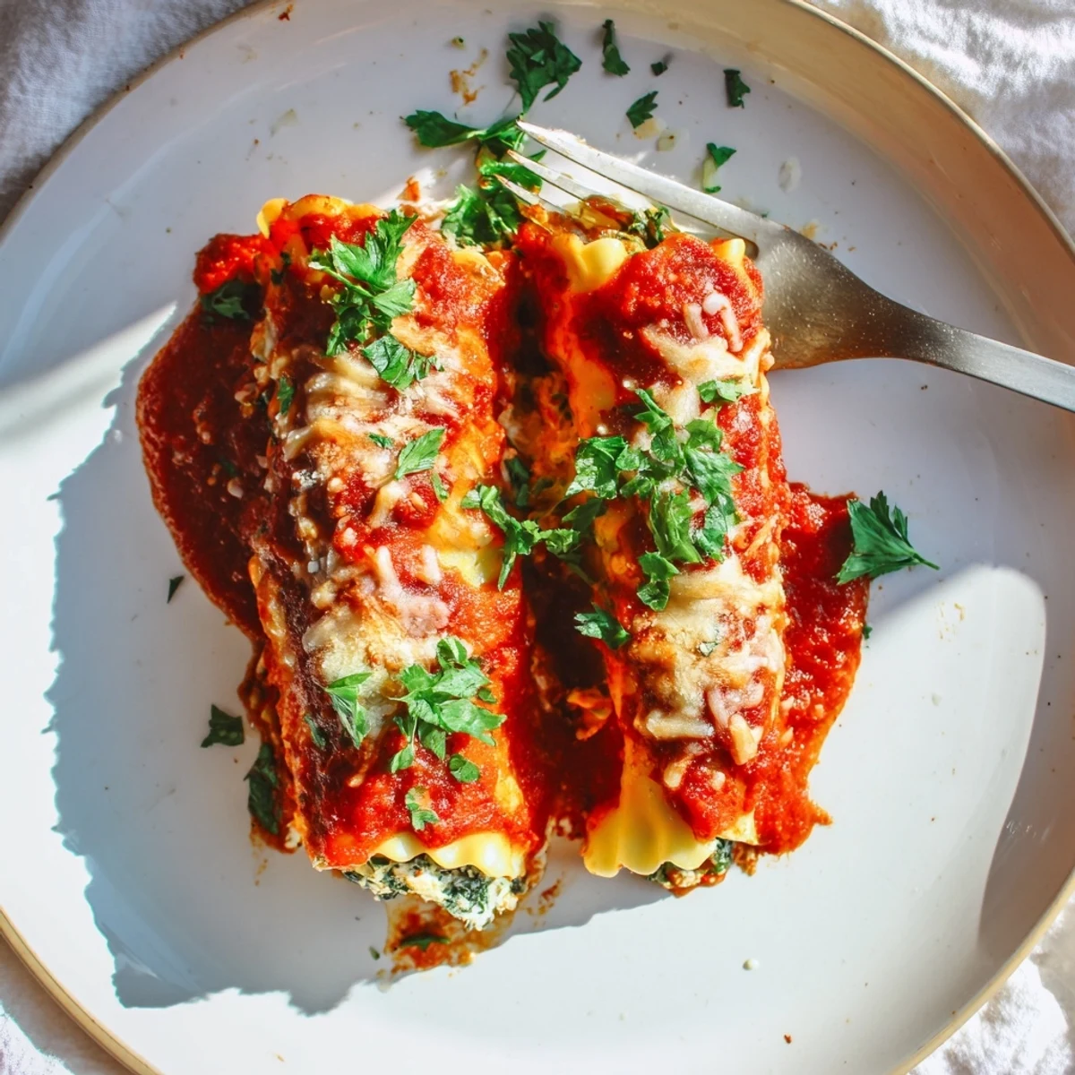 Golden-brown Chicken and Spinach Lasagna Rolls, baked in a ceramic dish with bubbling marinara sauce and melted mozzarella, ready to serve with fresh parsley garnish.