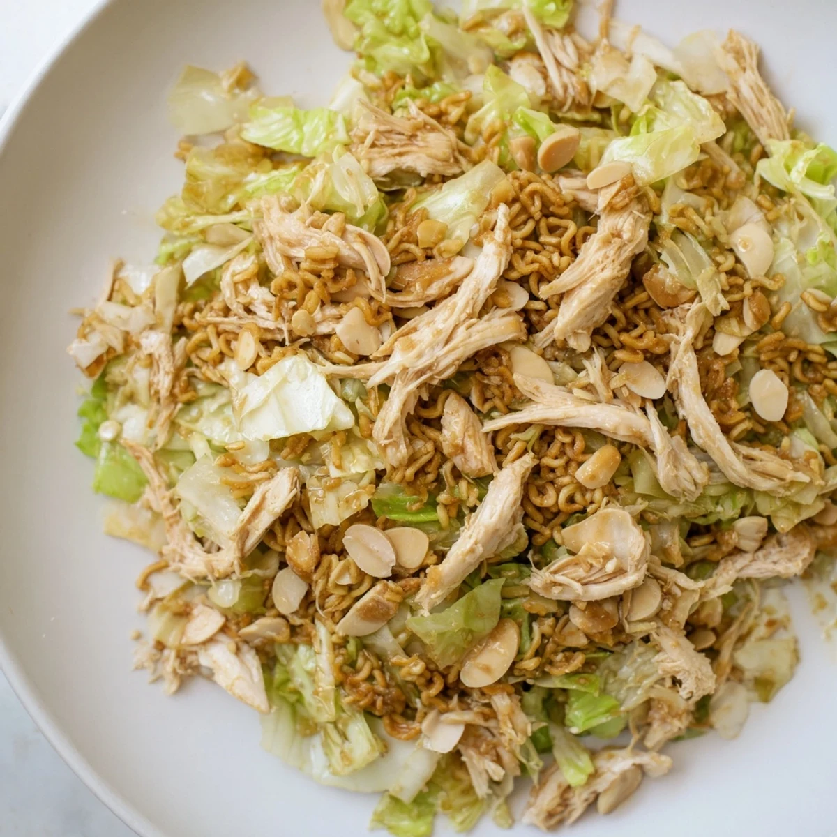 Colorful American-Asian fusion ramen chicken salad with tender chicken, fresh cilantro, and a glossy sesame vinaigrette.
