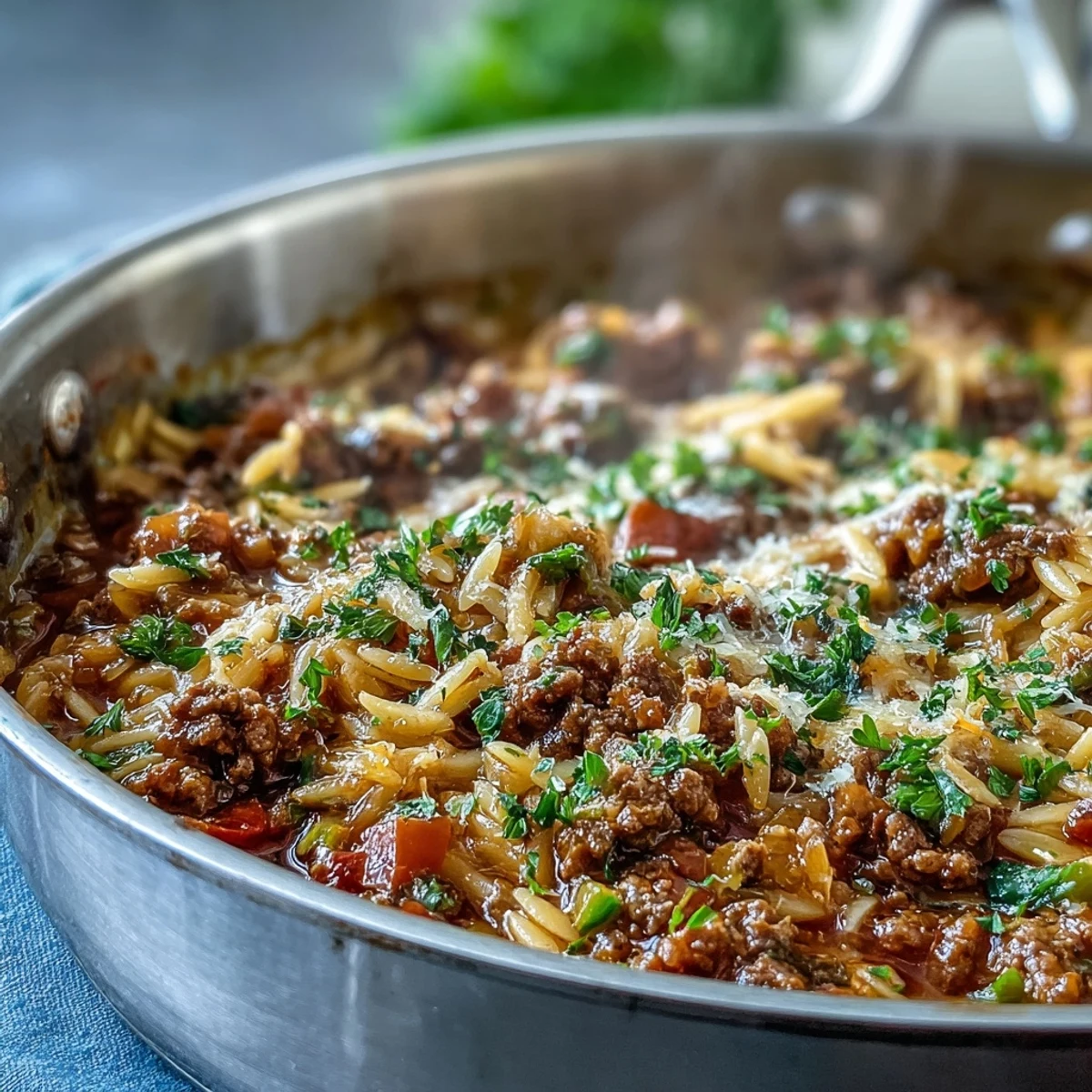 Steam rises from the savory Comforting Ground Beef Orzo Dinner, featuring tender orzo and colorful bell peppers.