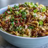 Sizzling ground pork and crunchy cabbage slaw are tossed in a savory ginger-soy sauce in this deconstructed Egg Roll in a Bowl. 