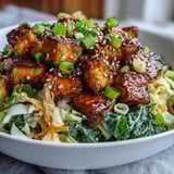 A close-up view of a vibrant, plant-based Tofu Egg Roll in a Bowl, garnished with fresh green onions and sesame seeds.