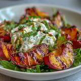 A vibrant summer salad with sweet grilled peaches, creamy burrata, and a honey drizzle, perfect for warm evenings.