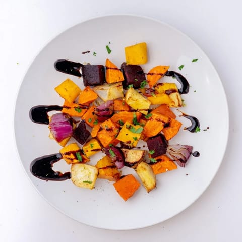 Golden-brown roasted root vegetable medley glistening with balsamic glaze, ready to serve warm.