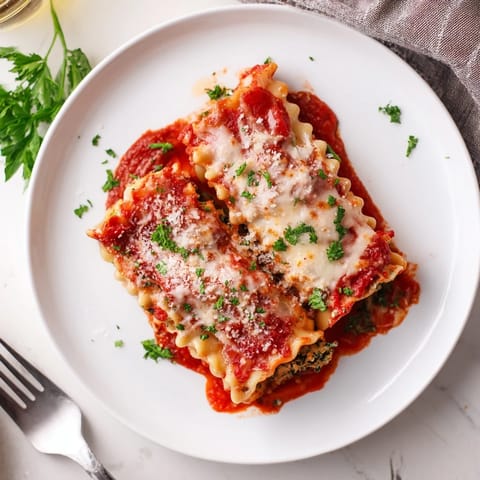 A close-up view of Chicken and Spinach Lasagna Rolls, revealing creamy ricotta, tender chicken, and vibrant green spinach wrapped in al dente pasta noodles.