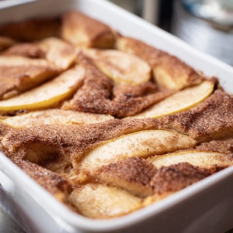 Freshly baked Baked Apple Cake with golden crust and soft apple filling, ready to be enjoyed with a hot cup of coffee.