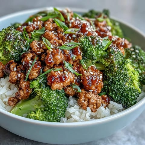 Steam rises from a freshly prepared Sweet and Spicy Turkey Broccoli Bowl, showcasing tender turkey and bright green broccoli florets.