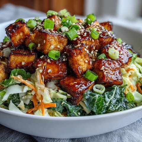 A close-up view of a vibrant, plant-based Tofu Egg Roll in a Bowl, garnished with fresh green onions and sesame seeds.