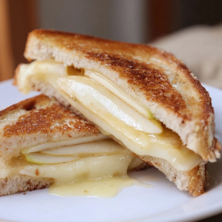 Mouthwatering Brie and Apple Grilled Cheese with melted Brie cheese, apples, and toasted sourdough, ready to eat.