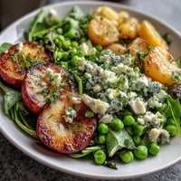 Bright lemon vinaigrette spring salad with radishes and peas in a white bowl
